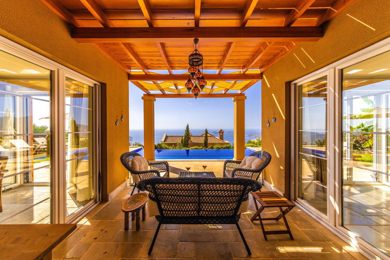A patio with chairs and a table overlooking the ocean